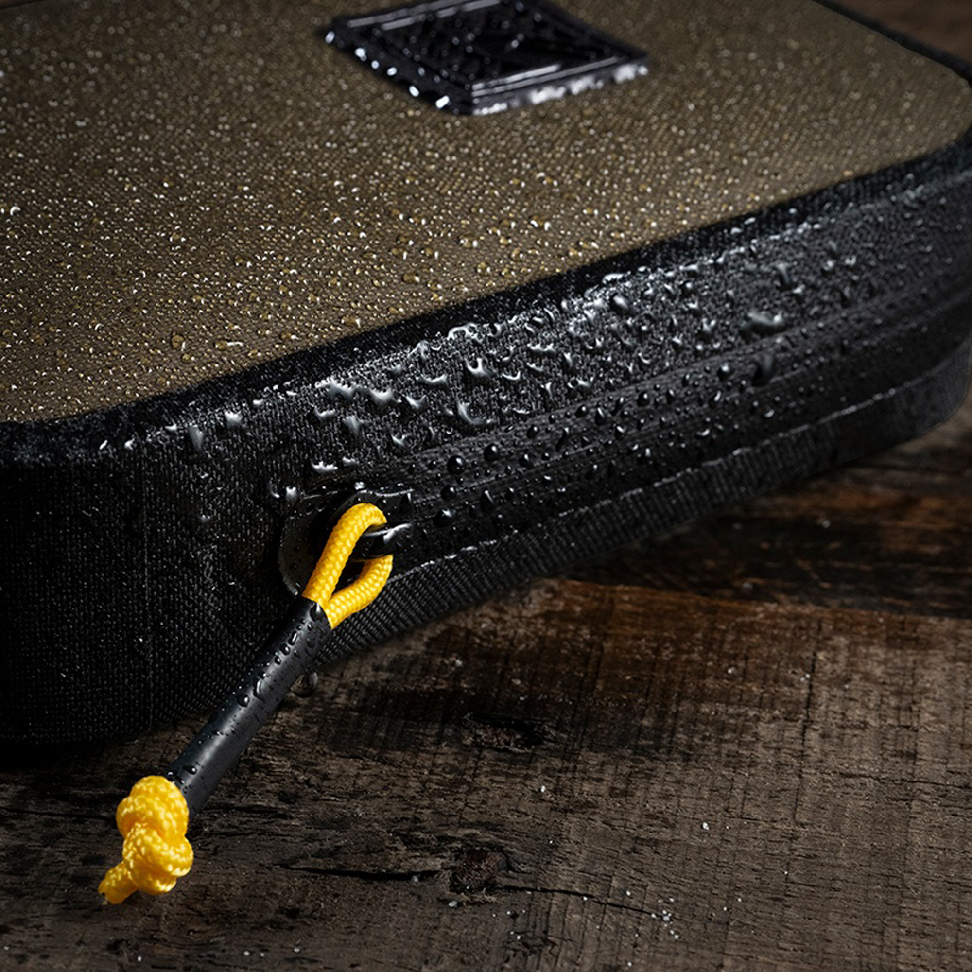 Close-up of a black pouch with zipper on a wooden surface