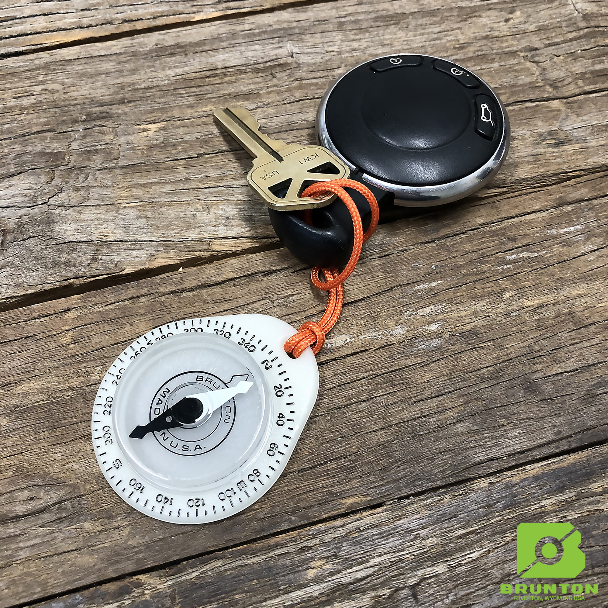 Keychain with compass attached on a wooden surface
