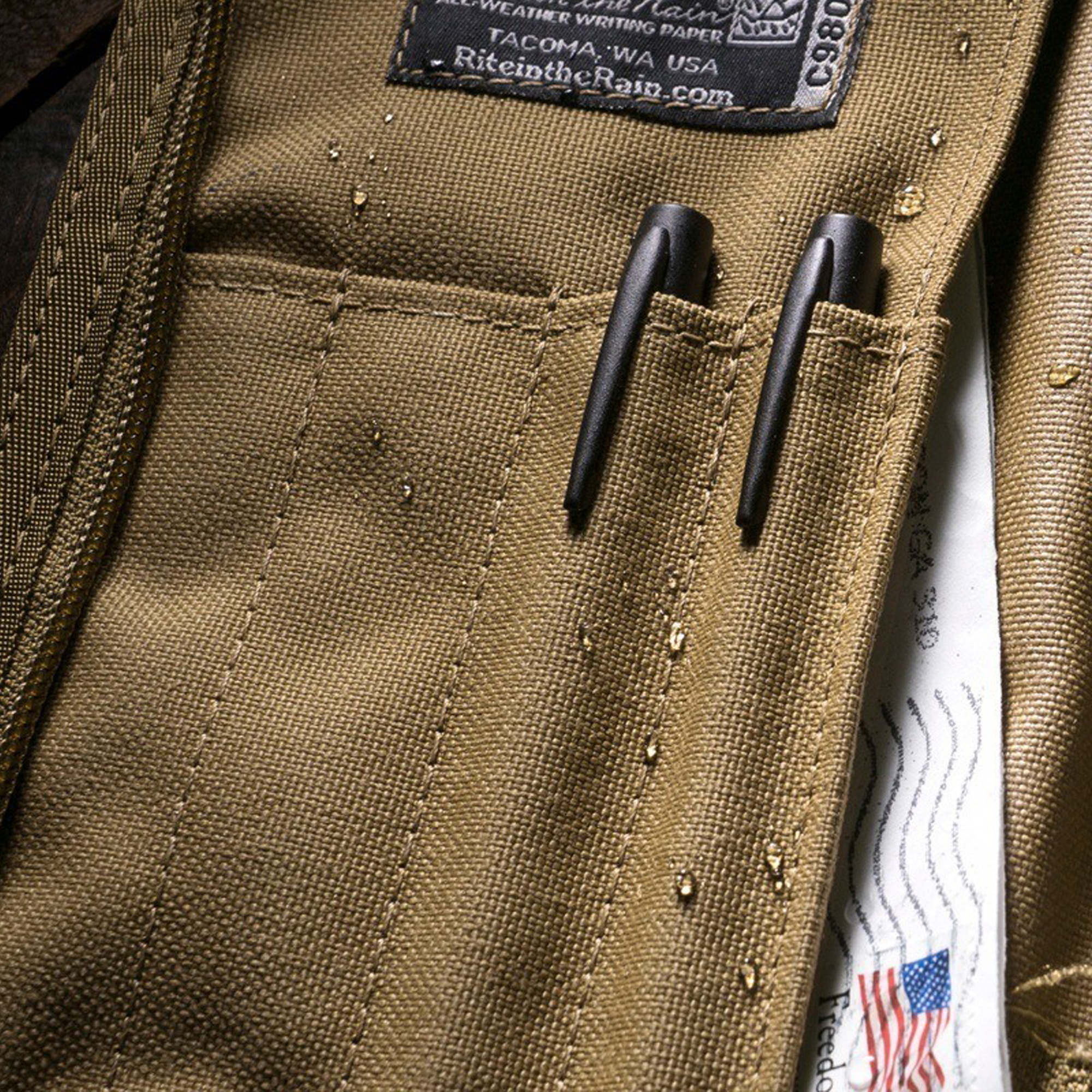 Close-up of a brown tactical cover with a label and pen pockets