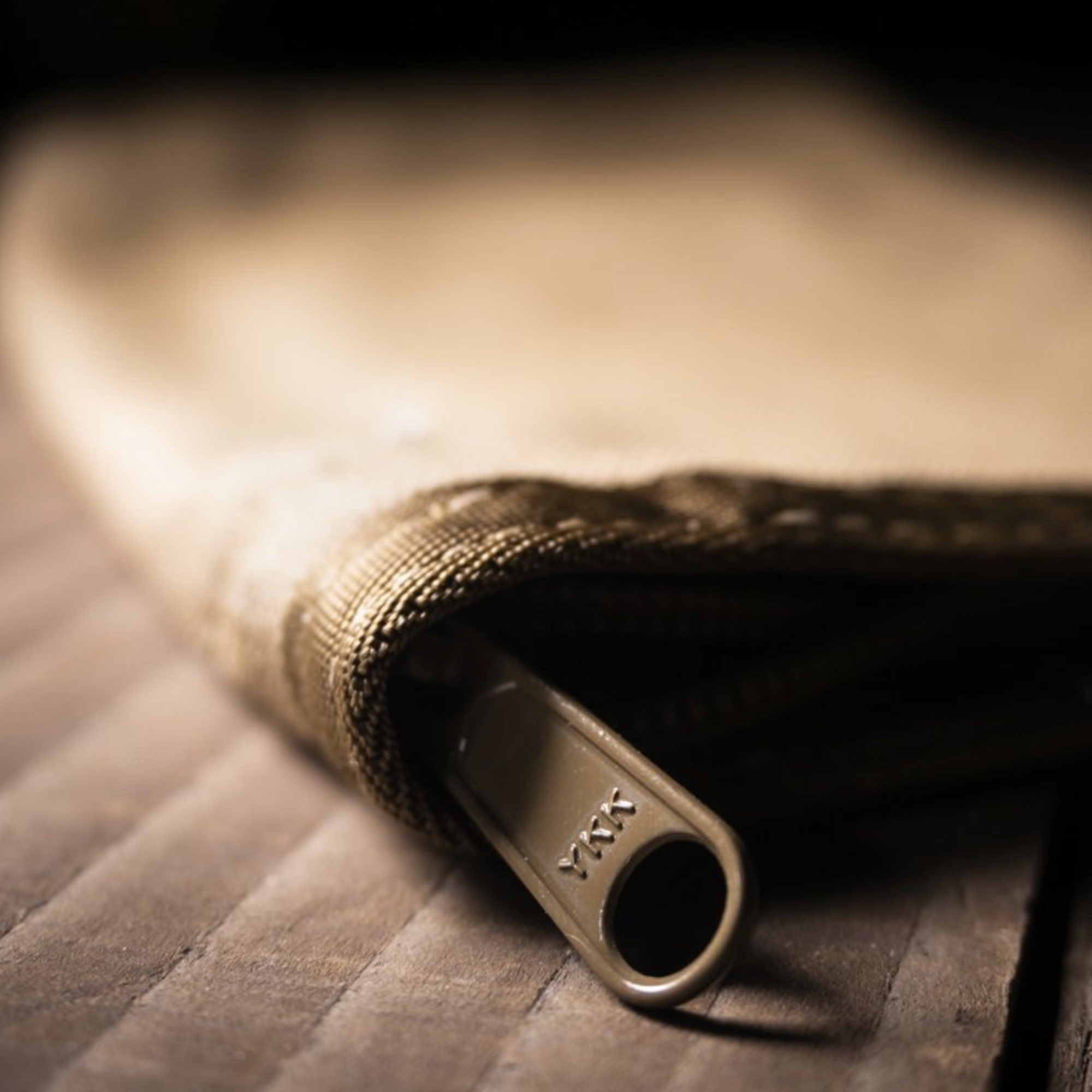 Tan cover with a tan zipper on a wooden surface