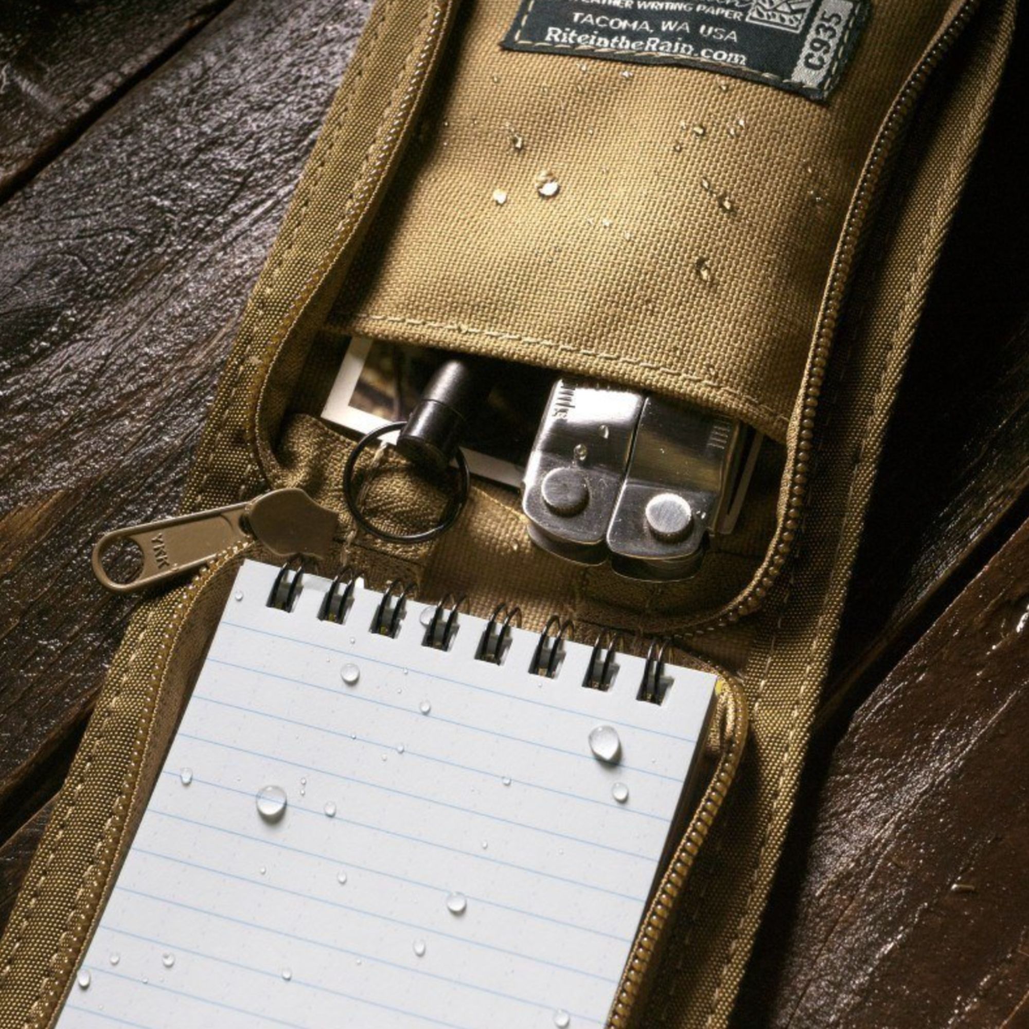 Brown pouch with tools and a notepad on a wooden surface
